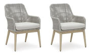 Seton Creek outdoor seating set by Ashley Furniture featuring a sofa, chairs, and a table with cushions in a garden setting