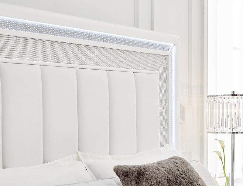 Ashley Furniture Chalanna upholstered storage bed with a padded headboard and built-in storage drawers in a modern bedroom setting.
