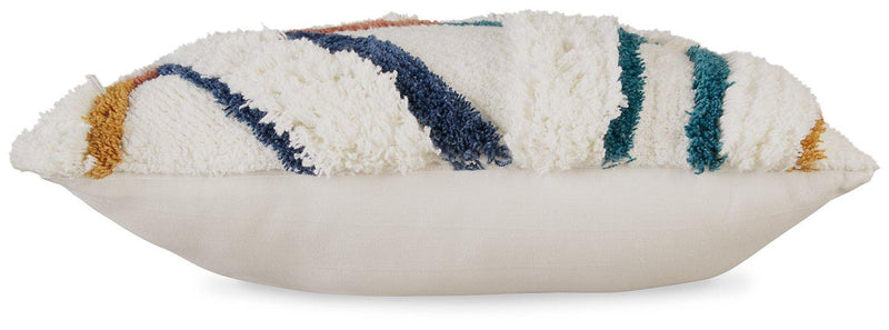 Set of four Ashley Furniture Evermore pillows with soft fabric covers and decorative stitching, arranged on a cozy bed.