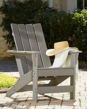Ashley Furniture Visola outdoor Adirondack chair and end table set, shown in a cozy outdoor seating arrangement.