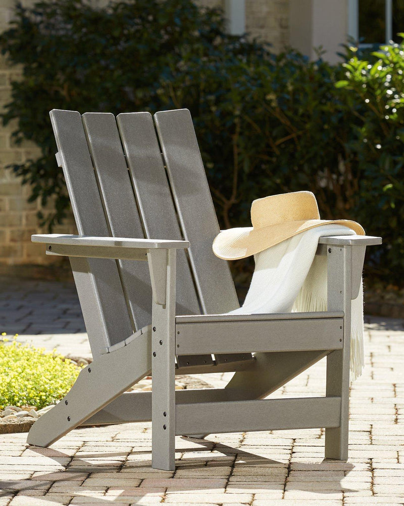 Ashley Furniture Visola outdoor Adirondack chair and end table set, shown in a cozy outdoor seating arrangement.