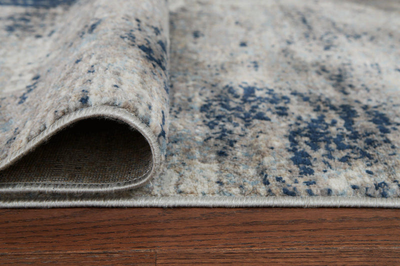 Wrenstow 7'10" x 10'3" rug by Ashley Furniture, featuring a stylish design with neutral tones and textured pattern.