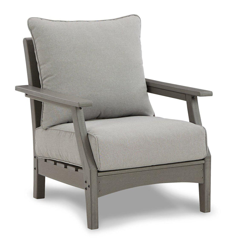 Ashley Furniture Visola outdoor loveseat conversation set with cushioned seats, coffee table, and outdoor decor on a patio.