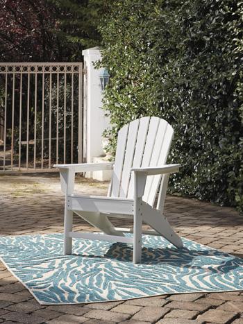 Outdoor table set from Ashley Furniture with a glass-top table and cushioned chairs in a garden setting.