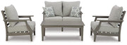 Ashley Furniture Visola outdoor loveseat conversation set with cushioned seats and matching coffee table in a backyard setting