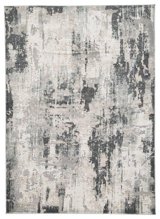 Ashley Furniture Mazatl 7'10" x 10'2" rug with intricate patterns and warm colors, displayed on a wooden floor.