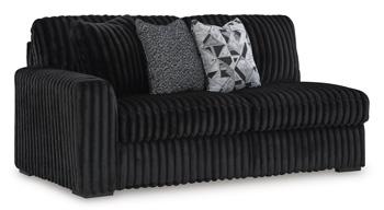 Ashley Furniture Midnight-Madness sectional sofa with plush cushions and dark fabric upholstery, shown in a modern living room setting.