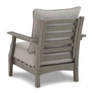 Ashley Furniture Visola outdoor loveseat conversation set with cushioned seats and armrests in a garden setting.