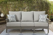 Ashley Furniture Visola outdoor seating set with sofa, loveseat, and coffee table arranged on a patio.