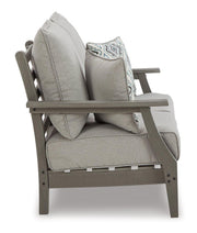 Outdoor loveseat conversation set by Ashley Furniture with cushioned seats and a coffee table, perfect for outdoor relaxation.