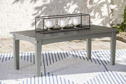 Outdoor table set by Ashley Furniture with two round tables and matching chairs in a garden setting.