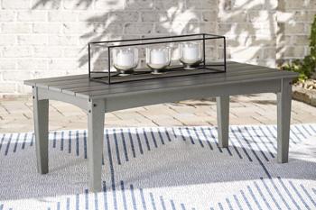Outdoor table set by Ashley Furniture with two round tables and matching chairs in a garden setting.