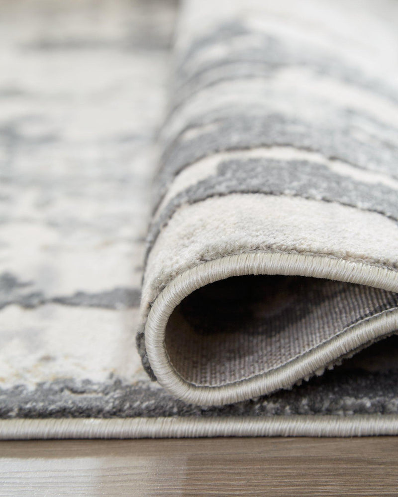 Ashley Furniture Mazatl 7'10" x 10'2" rug with intricate pattern and soft texture, suitable for living rooms or bedrooms.