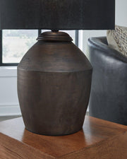 Naareman Ashley Furniture table lamp with a sleek design, featuring a fabric lampshade and a modern base on a wooden surface.