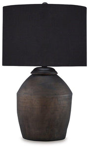 Naareman table lamp by Ashley Furniture with a modern ceramic base and fabric shade, placed on a wooden side table.