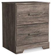 Ashley Furniture Ralinksi nightstand with a wooden finish and single drawer, featuring a modern design and sleek metal handle.