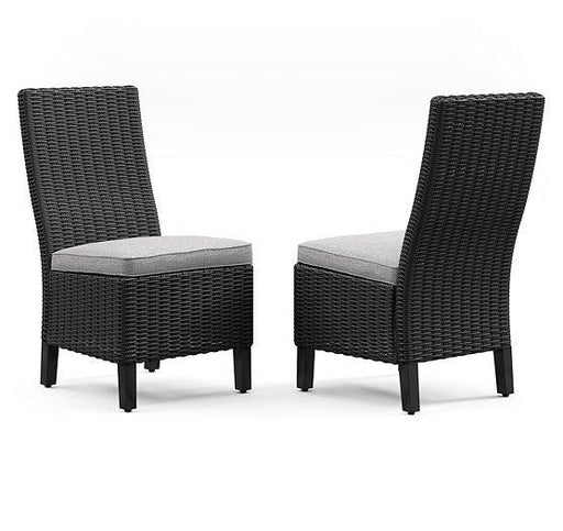 Set of two Ashley Furniture Beachcroft outdoor dining side chairs with cushions, featuring weather-resistant metal frames and woven seats.