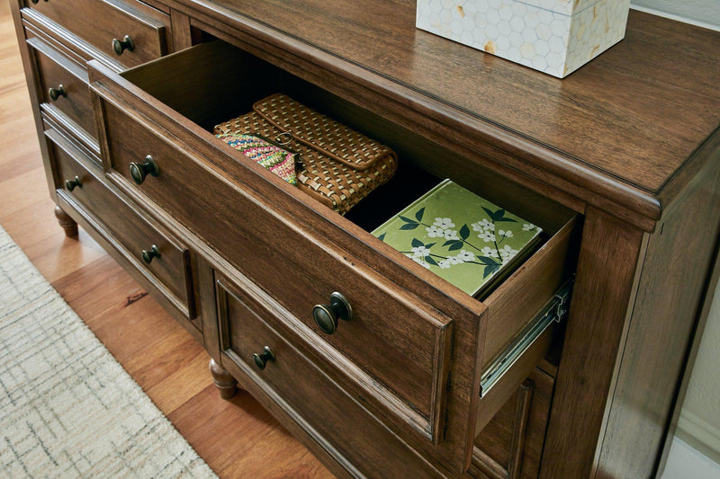 Ashley Furniture Sturlayne dresser and mirror set with wooden finish, featuring multiple drawers and an elegant matching mirror.
