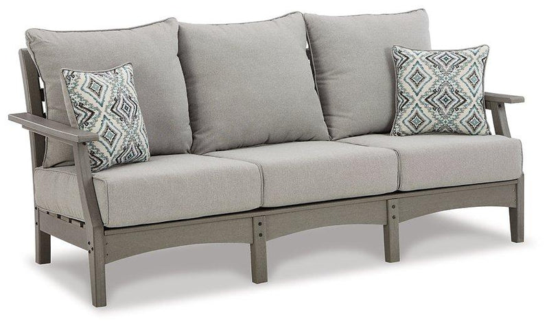 Outdoor seating set with Ashley Furniture sofa, loveseat, and coffee table featuring woven rattan design and plush cushions.
