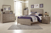 Ashley Furniture Culverbach Bed with a classic wooden frame and detailed headboard, shown in a cozy bedroom setting.