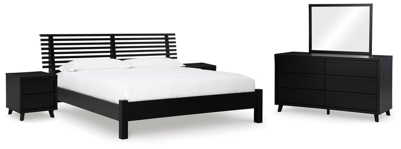 Ashley Furniture Danziar bedroom set with a modern bed frame, matching nightstands, and a stylish dresser in a contemporary bedroom.