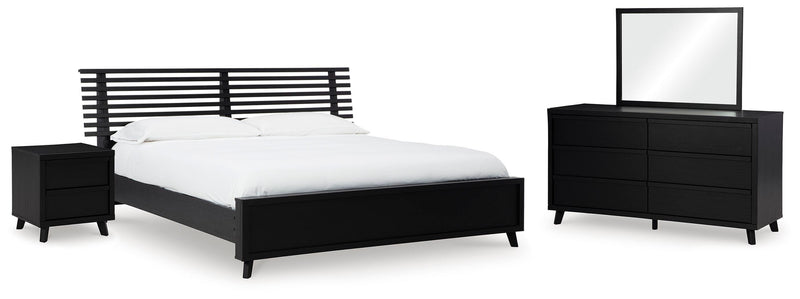 Ashley Furniture Danziar bedroom set with a modern bed frame, nightstands, and matching dresser in a stylish bedroom setting.