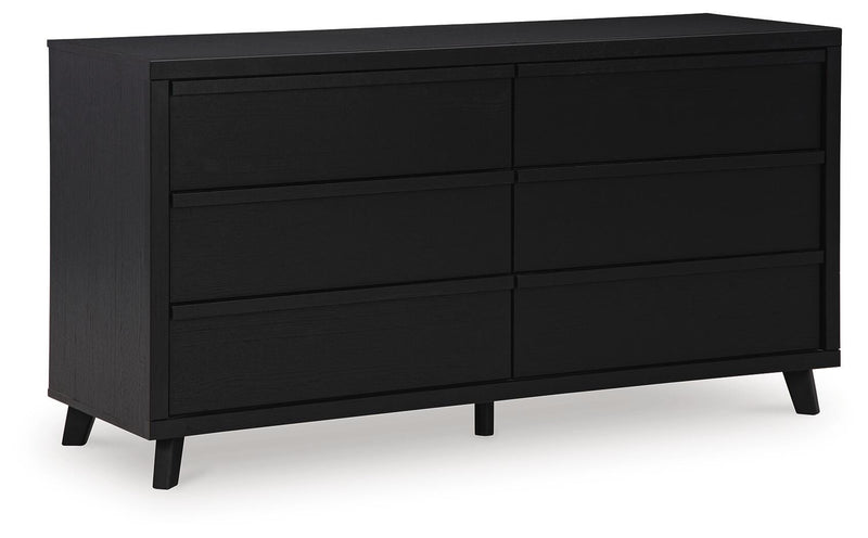 Ashley Furniture Danziar dresser with multiple drawers, hardwood finish, and sleek modern design, viewed from a side angle.