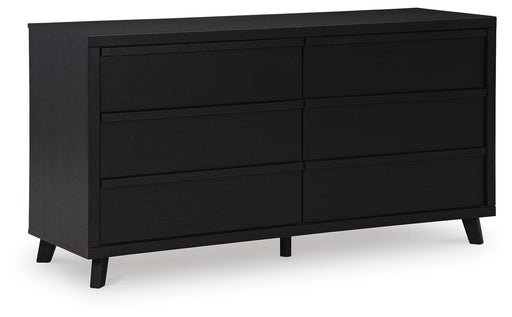 Ashley Furniture Danziar dresser with multiple drawers, hardwood finish, and sleek modern design, viewed from a side angle.