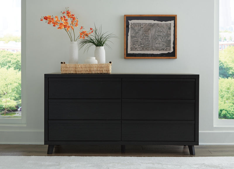 Ashley Furniture Danziar Dresser with multiple drawers and sleek wood finish, showcasing a modern bedroom storage solution.