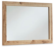 Ashley Furniture Hyanna dresser with matching mirror, showcasing a stylish wooden storage unit and mirror in a modern bedroom setup.