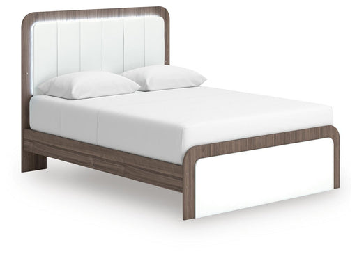 Ashley Furniture Kendanport upholstered bed shown from an angled side view in a well-lit bedroom setting.