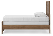 Ashley Furniture Broachmyn Bed with a stylish upholstered headboard and wooden frame, shown from a side angle.