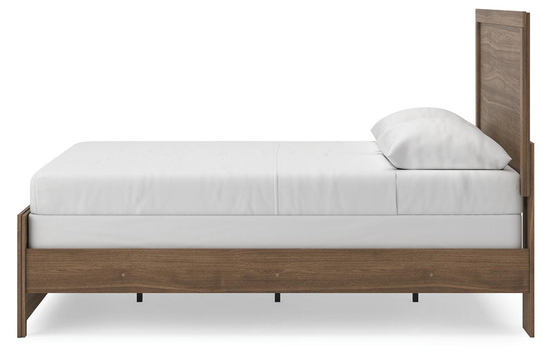 Ashley Furniture Broachmyn Bed with upholstered headboard and wooden frame, shown in a cozy bedroom setting.