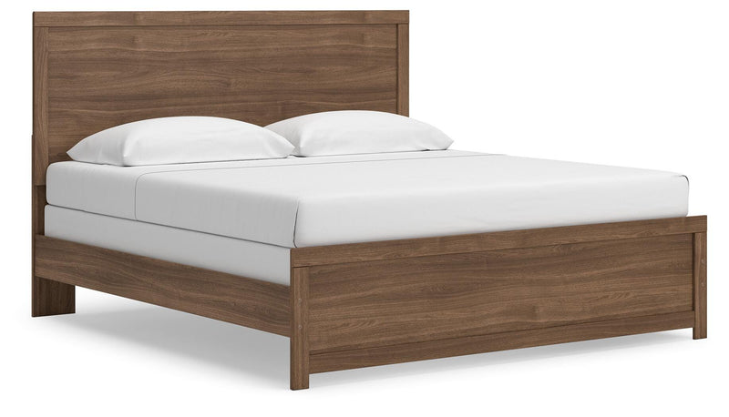 Ashley Furniture Broachmyn Bed in a stylish bedroom setting with a wooden headboard and neutral bedding, angled view showing design details.