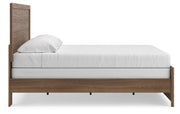 Ashley Furniture Broachmyn Bed with wooden frame and upholstered headboard, shown from side view in a modern bedroom setting.