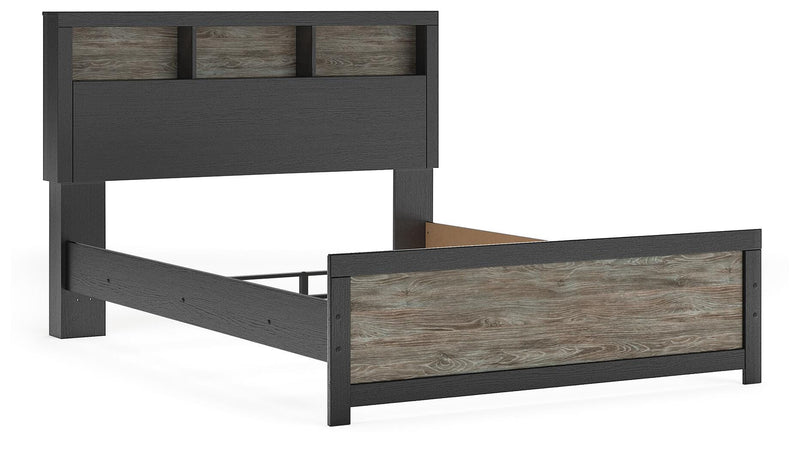 Ashley Furniture Broachmyn Bed with a modern upholstered headboard and wooden frame, shown from an angled side view.
