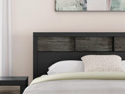 Ashley Furniture Broachmyn Bed with a detailed wooden headboard and frame in a natural finish, shown in a stylish bedroom setting.