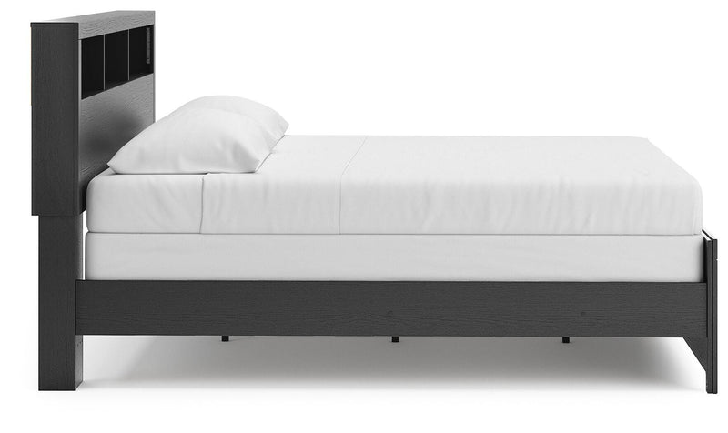 Ashley Furniture Broachmyn Bed with side view showcasing its elegant wooden frame and detailed headboard design.