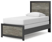 Angled view of the Broachmyn Bed by Ashley Furniture, showcasing its elegant wooden frame and upholstered headboard.