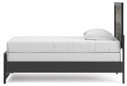 Ashley Furniture Broachmyn Bed with a wooden frame and upholstered headboard, shown from a side angle.