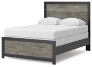 Ashley Furniture Broachmyn Bed with a stylish wooden frame and upholstered headboard, shown from an angled side view.