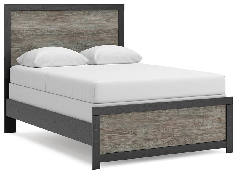 Ashley Furniture Broachmyn Bed with a stylish wooden frame and upholstered headboard, shown from an angled side view.