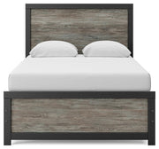 Ashley Furniture Broachmyn Bed with a headboard featuring detailed woodwork and a dark finish.