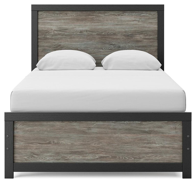 Ashley Furniture Broachmyn Bed with a headboard featuring detailed woodwork and a dark finish.