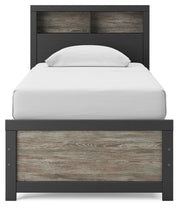 Ashley Furniture Broachmyn Bed with upholstered headboard and wooden frame, shown from a front angle.