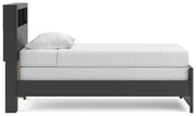 Ashley Furniture Broachmyn Bed with a stylish wooden frame and neutral upholstery, shown from a side view.