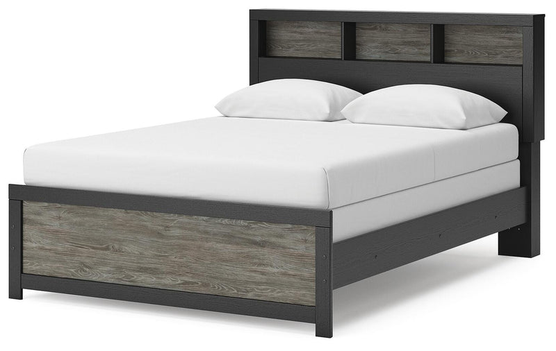 Ashley Furniture Broachmyn Bed with upholstered headboard and wooden frame, shown from an angled side view.