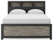 Ashley Furniture Broachmyn Bed with a headboard featuring detailed woodwork and a dark finish, showcasing a stylish bedroom setup.
