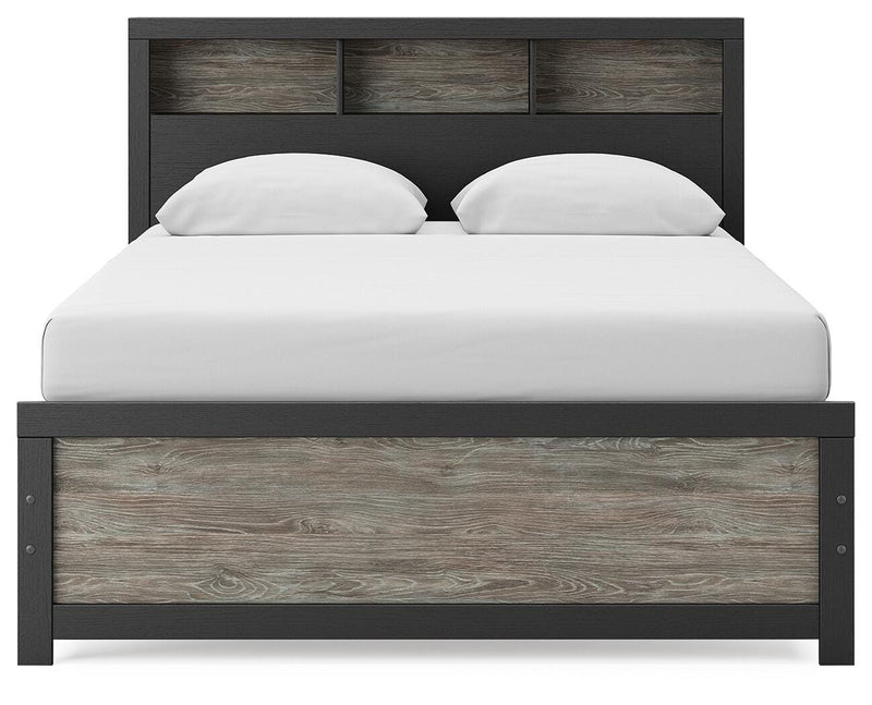 Ashley Furniture Broachmyn Bed with a headboard featuring detailed woodwork and a dark finish, showcasing a stylish bedroom setup.