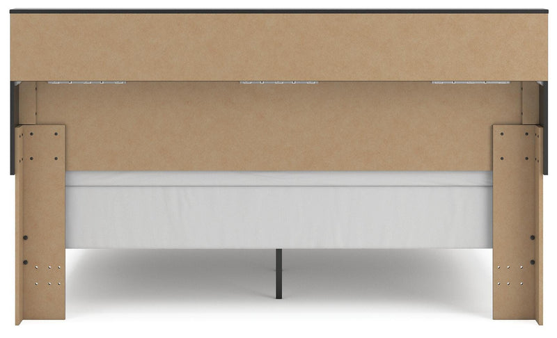 Ashley Furniture Broachmyn Bed with upholstered headboard and wooden frame, shown in a cozy bedroom setting.